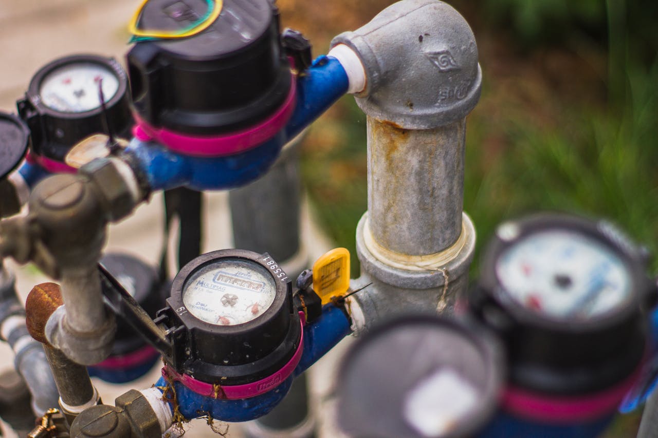 Services-01 Detailed image of industrial water pressure gauges and pipes in an outdoor setting.
